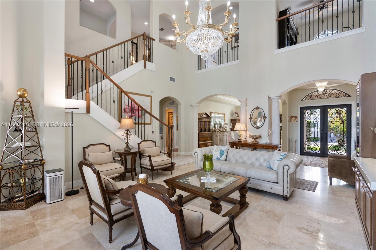 1495 Windjammer Way Hollywood, FL 33019 - Photo 6 of 48 a living room with furniture flowers and a chandelier