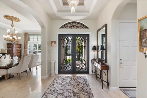 a view of a hallway with furniture and a chandelier