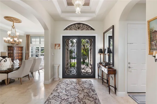a view of a hallway with furniture and a chandelier