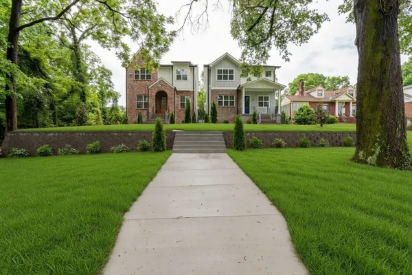 a front view of a house with a yard and potted plants