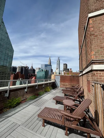 a view of a roof deck with table and chairs