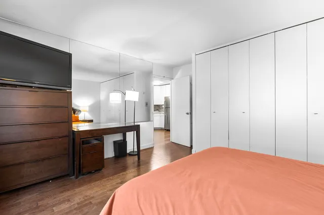 a living room with furniture a dining table and a refrigerator