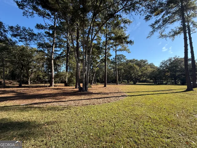 a view of a house with a yard and sitting area