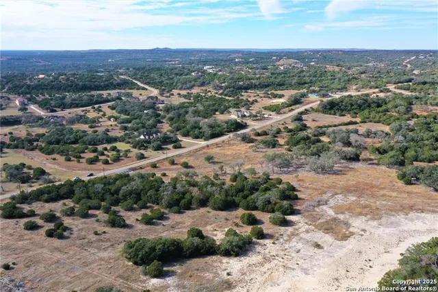 a view of a dry yard with wooden fence