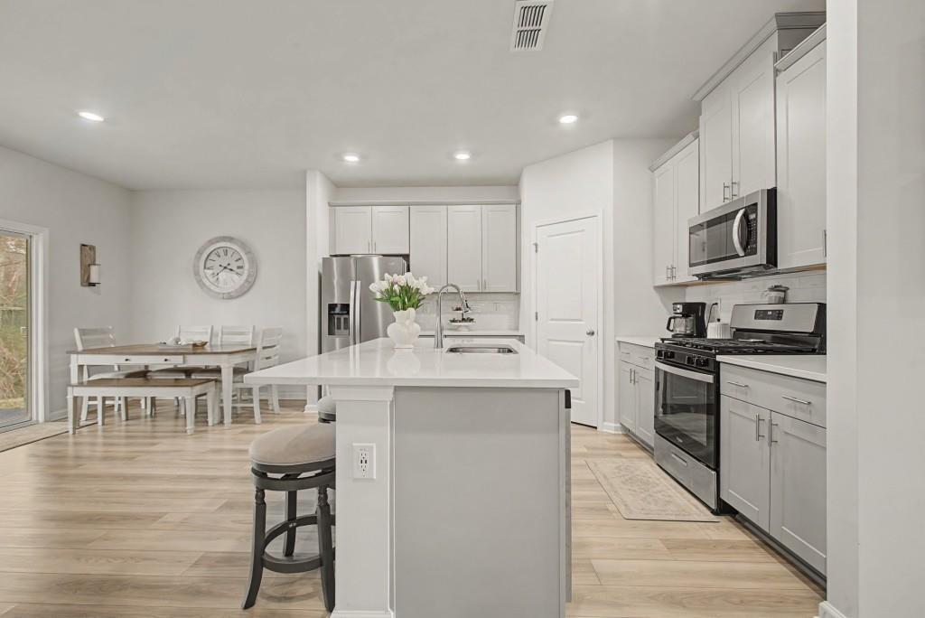 87 Cranson Walk Pendergrass, GA 30567 - Photo 12 of 50 a kitchen with kitchen island granite countertop stainless steel appliances cabinets a sink and a stove top oven