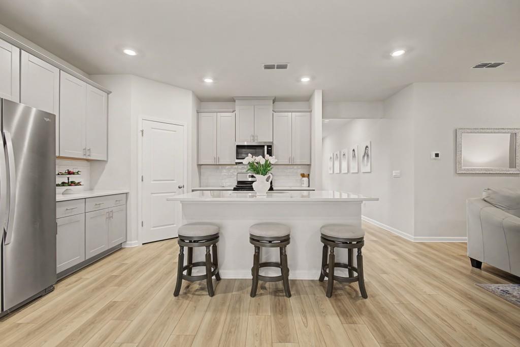 87 Cranson Walk Pendergrass, GA 30567 - Photo 14 of 50 a kitchen with stainless steel appliances a dining table chairs microwave and sink