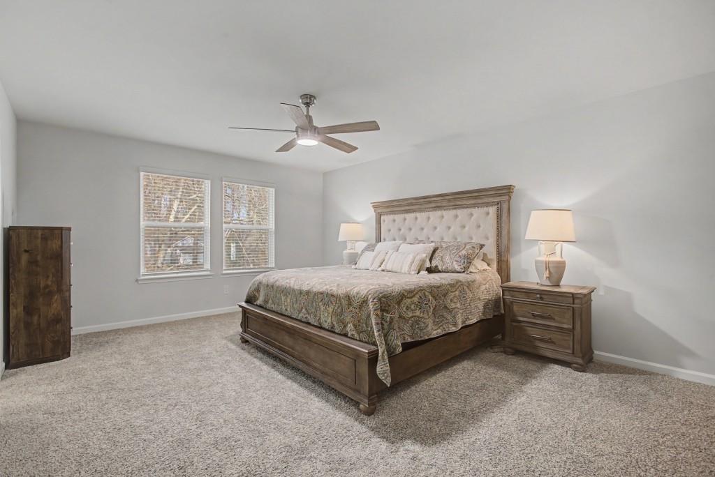 87 Cranson Walk Pendergrass, GA 30567 - Photo 27 of 50 a bedroom with a bed chandelier and a window