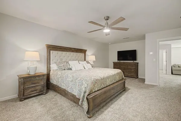 a spacious bedroom with a bed and a chandelier