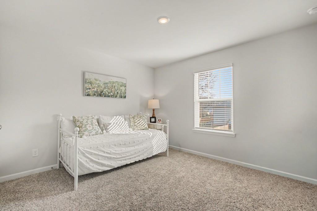 87 Cranson Walk Pendergrass, GA 30567 - Photo 34 of 50 a spacious bedroom with a bed a couch and a window