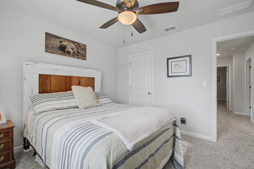 87 Cranson Walk Pendergrass, GA 30567 - Photo 37 of 50 a bedroom with a bed and a chandelier