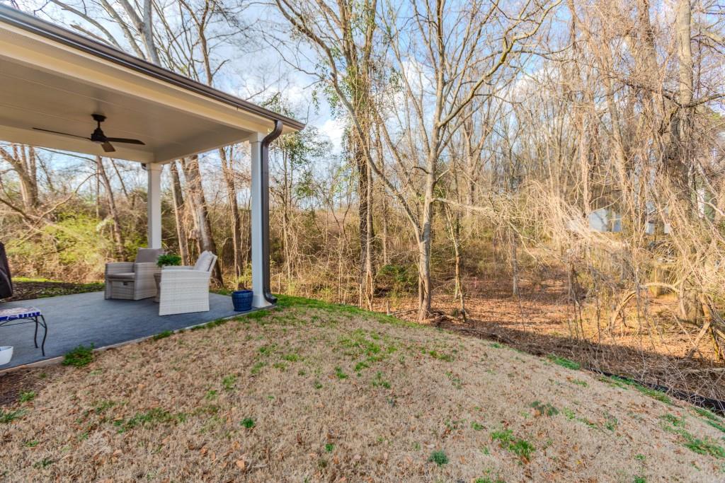 87 Cranson Walk Pendergrass, GA 30567 - Photo 47 of 50 a backyard of a house with table and chairs under an umbrella