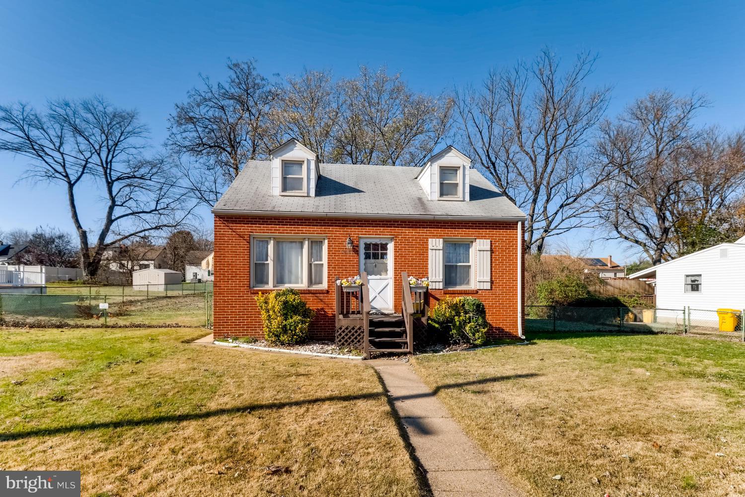 a front view of house with yard and trees around