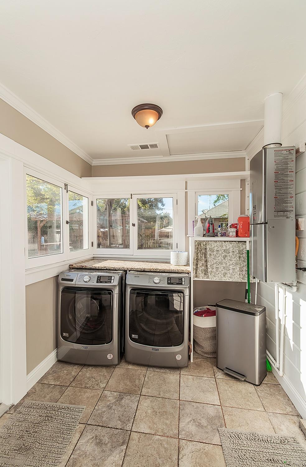1053 K Street Reedley, CA 93654 - Photo 18 of 62 a kitchen with granite countertop a stove top oven and stainless steel appliances