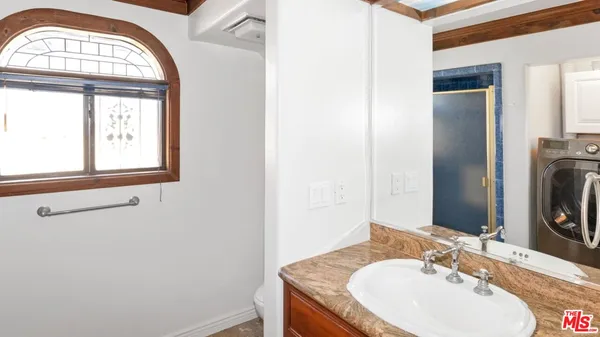 a bathroom with a tub a sink and a large mirror