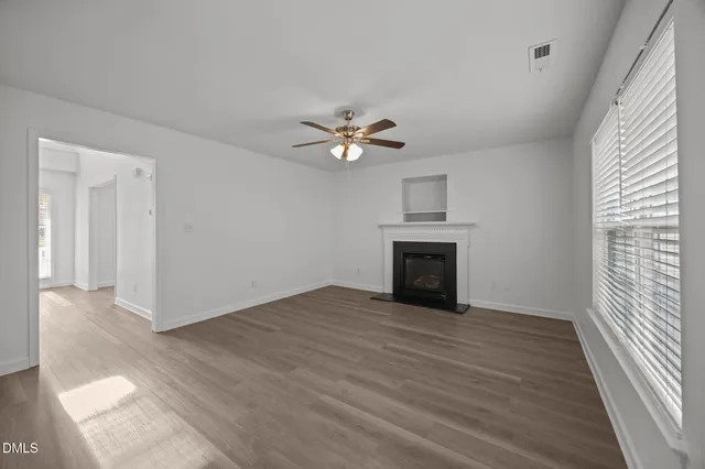 wooden floor fireplace and windows in an empty room