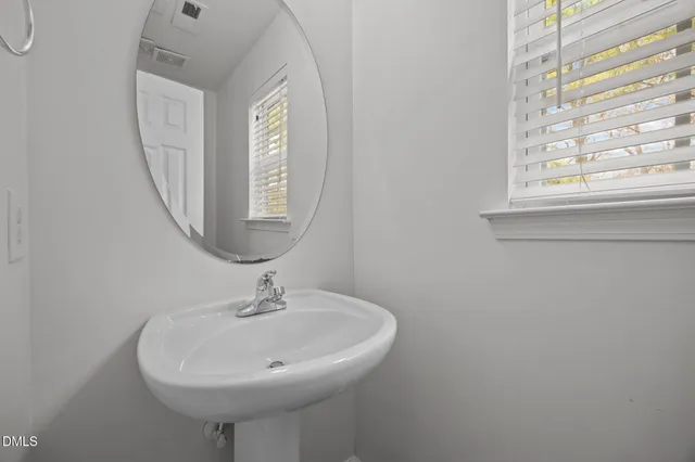 a bathroom with a sink a mirror and a window