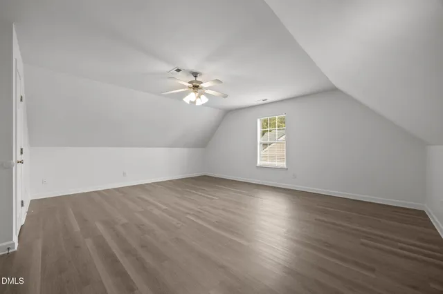 an empty room with wooden floor and chandelier fan