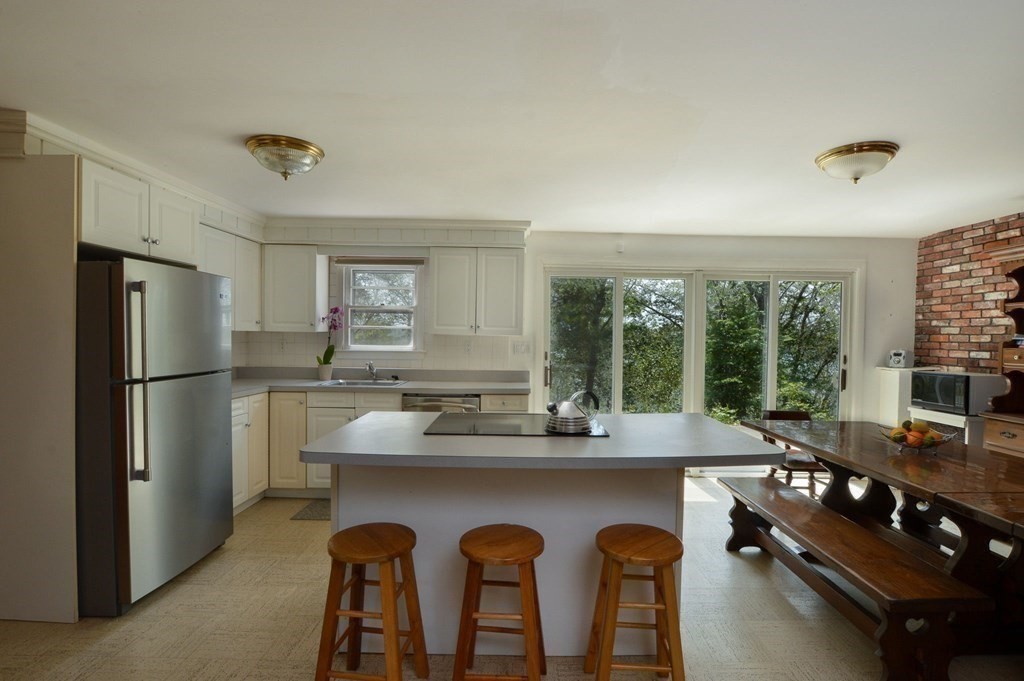230 Pimlico Pond Road Mashpee, MA 02649 - Photo 17 of 35 a dining room with furniture a large window and stainless steel appliances