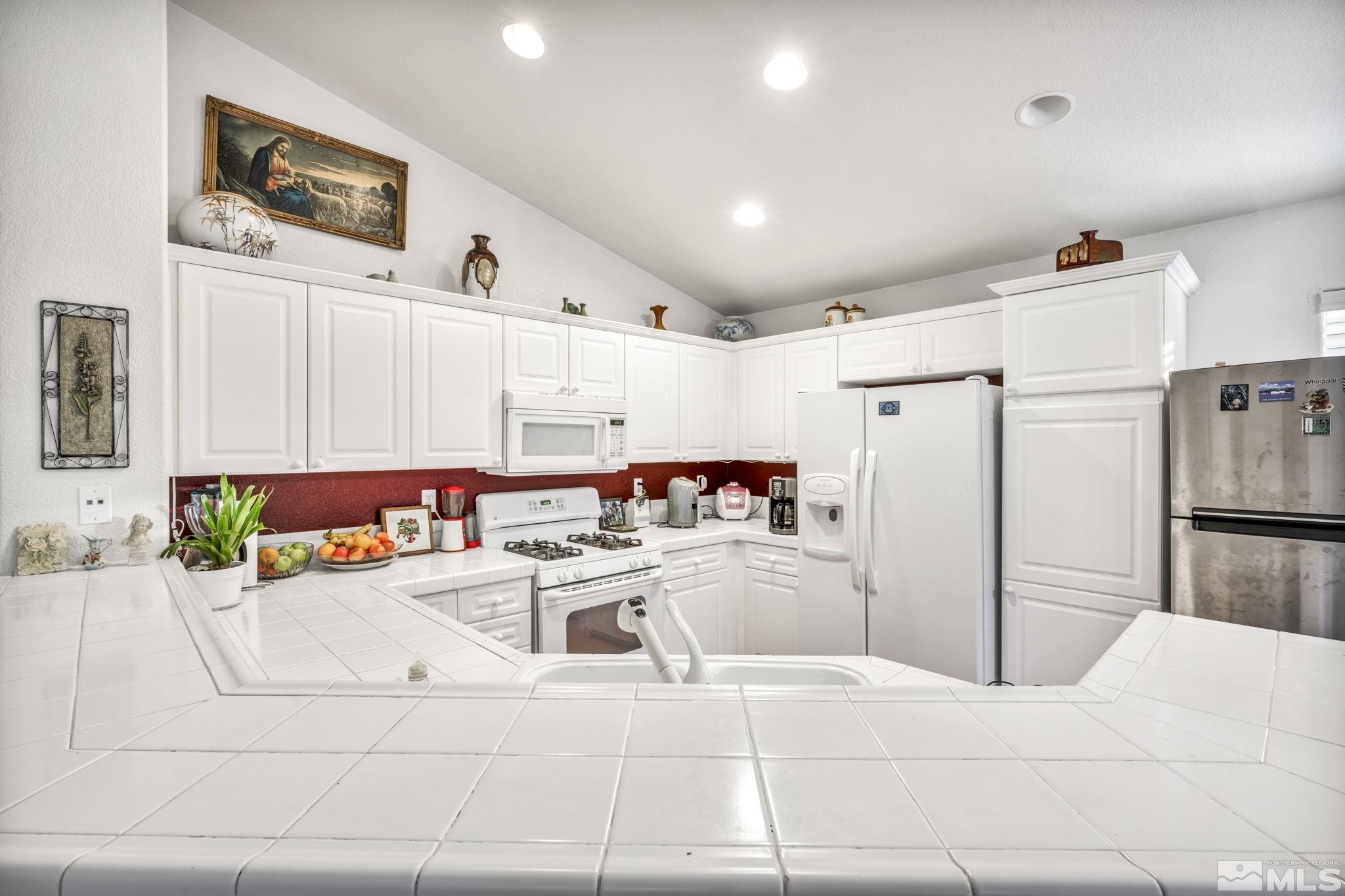 1770 Ornellaia Way Reno, NV 89521 - Photo 26 of 37 a kitchen with stainless steel appliances kitchen island granite countertop a refrigerator and a sink
