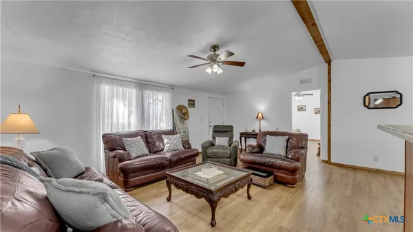 a living room with furniture a ceiling fan and a window