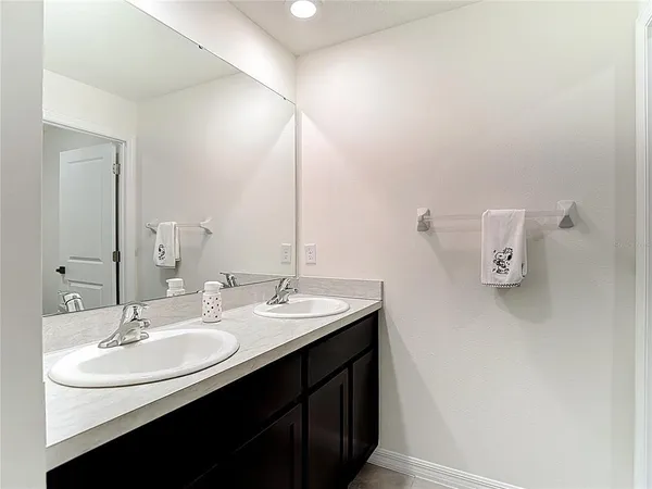 a bathroom with a sink and mirror with toilet