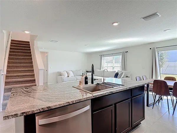a kitchen with kitchen island granite countertop a sink and cabinets
