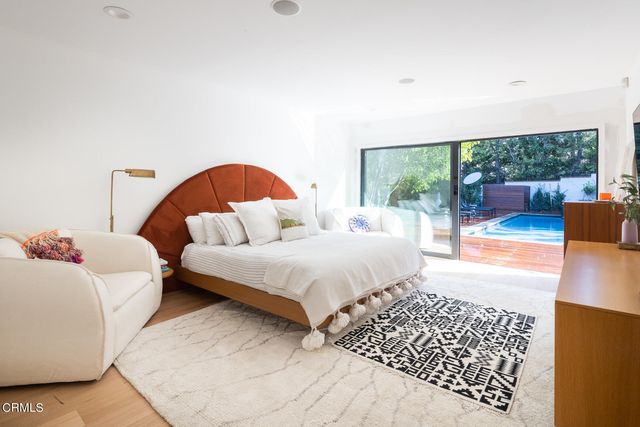 a bedroom with a bed lamp and a large window