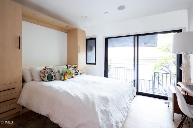 a bedroom with a bed and a flat tv screen next to a window