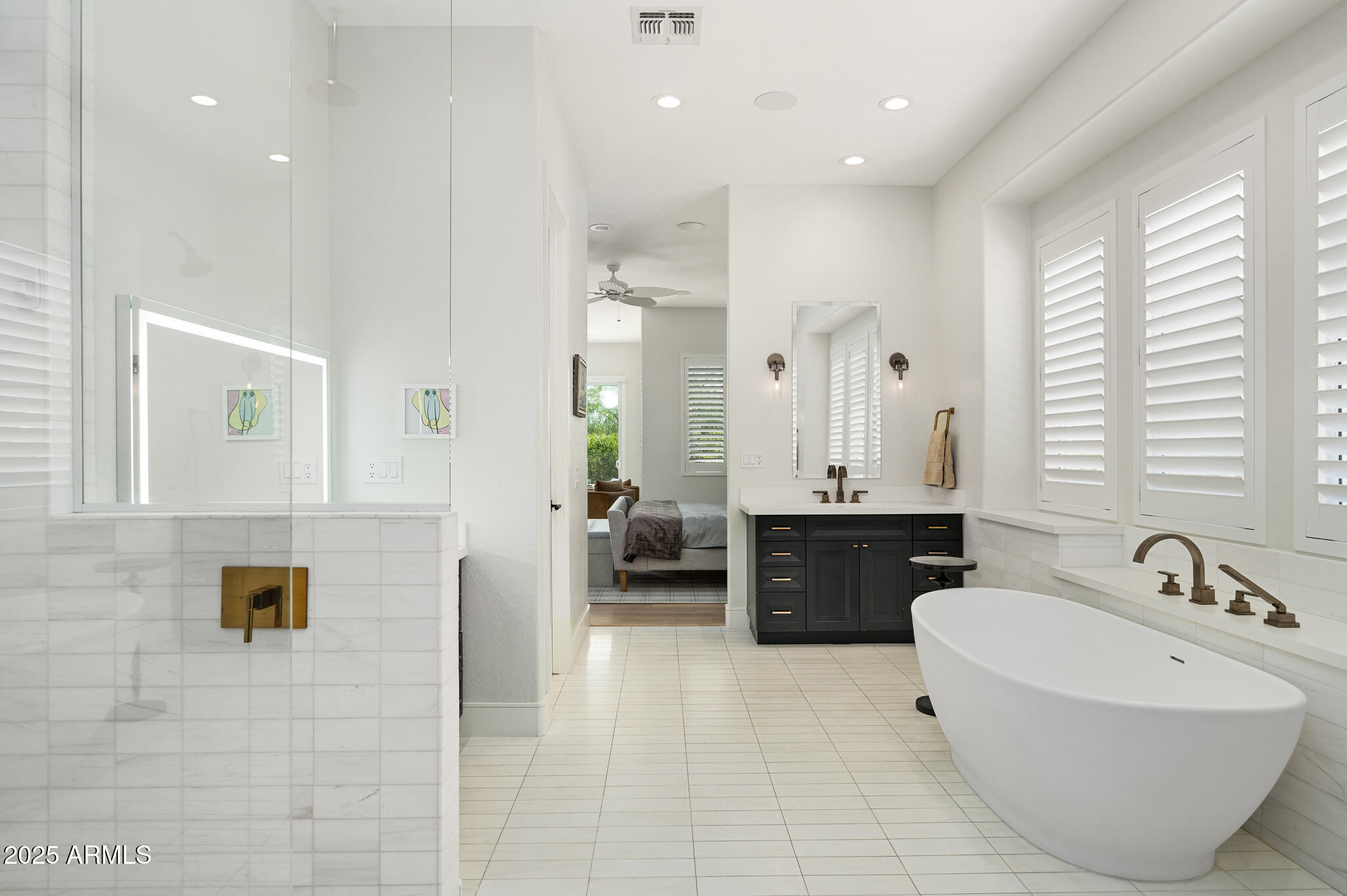 9631 East Mountain Spring Road Scottsdale, AZ 85255 - Photo 24 of 48 a spacious bathroom with a double vanity sink a mirror a bathtub and shower