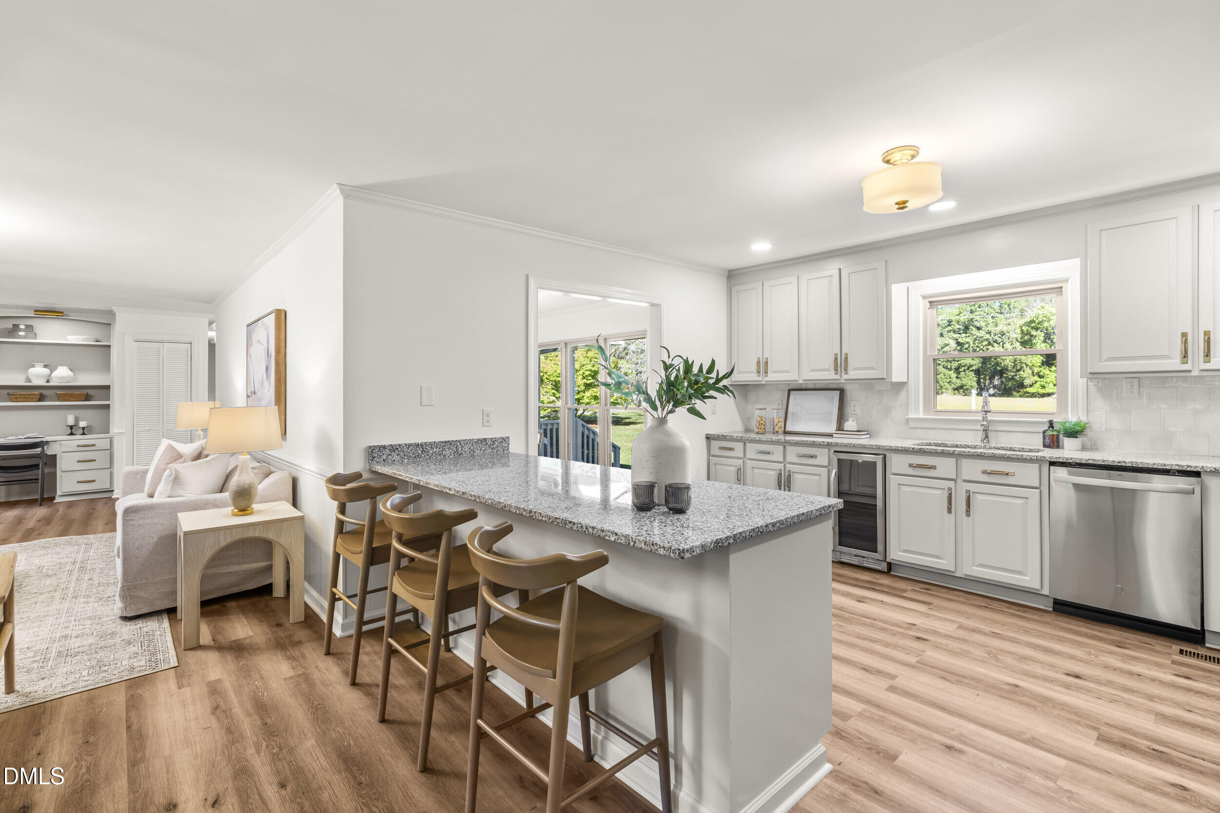 462 Sullivan Road Selma, NC 27576 - Photo 14 of 33 a kitchen with kitchen island granite countertop a table chairs a sink dishwasher stove and cabinets with wooden floor