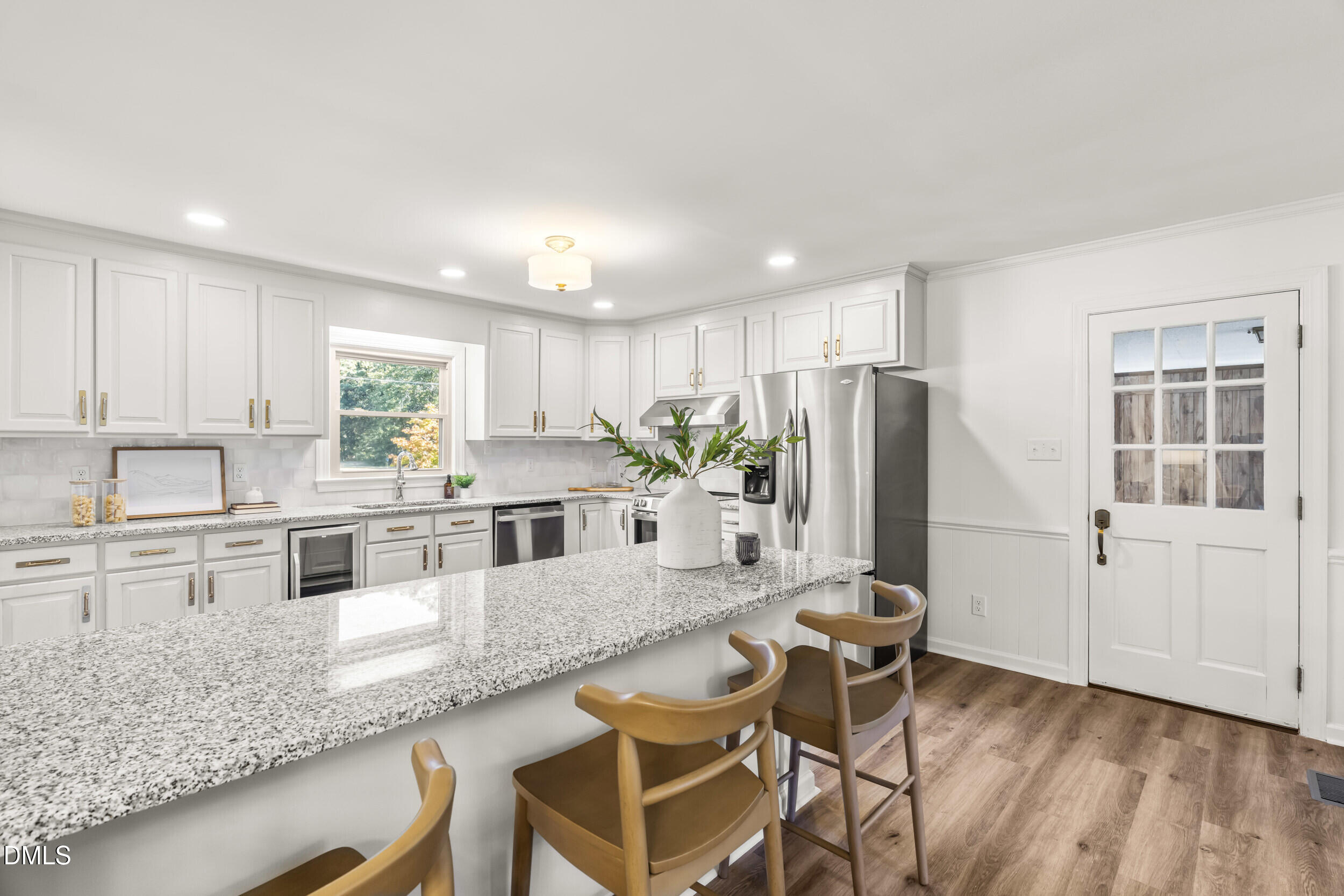 462 Sullivan Road Selma, NC 27576 - Photo 16 of 33 a kitchen with kitchen island granite countertop wooden floors and white cabinets