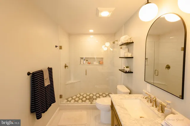 a bathroom with a granite countertop sink a mirror and shower