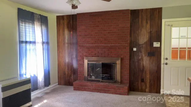 a view of a livingroom with fireplace and window