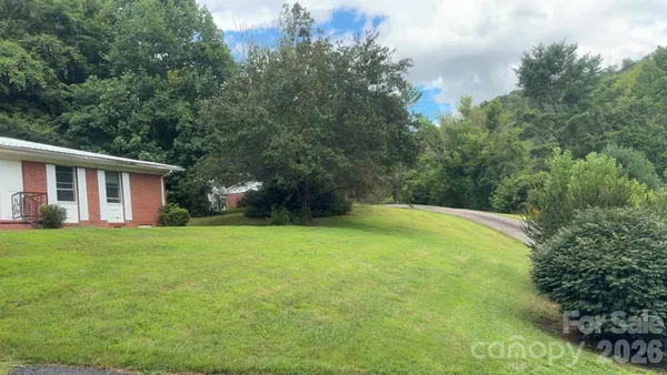 a view of a house with backyard and trees