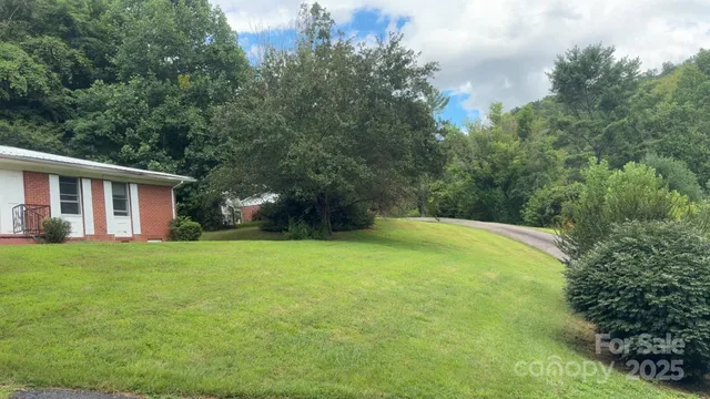 a view of a house with backyard and trees