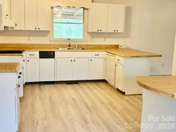 a kitchen with granite countertop white cabinets and white appliances