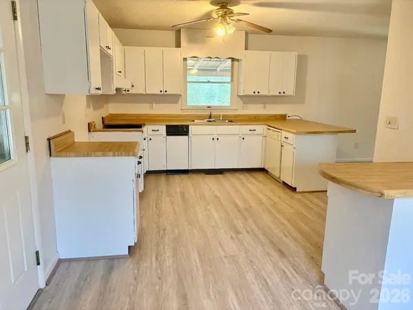 a kitchen with stainless steel appliances a sink a stove top oven a counter space and cabinets