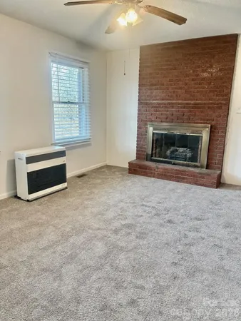 an empty room with windows and fireplace