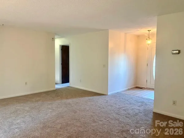 a view of an empty room with window and closet