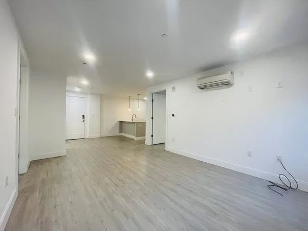 a view of empty room with wooden floor