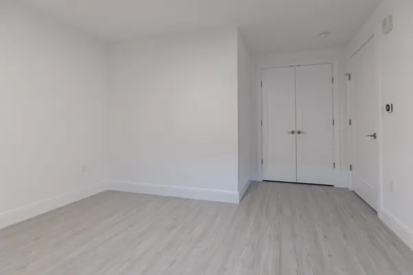 a view of an empty room with wooden floor