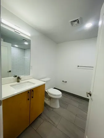 a bathroom with a toilet a sink and mirror