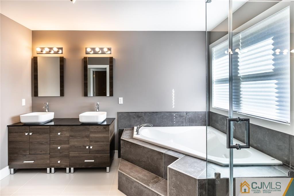 123 Millhurst Road Manalapan, NJ 07726 - Photo 14 of 27 a bathroom with a tub sink and mirror