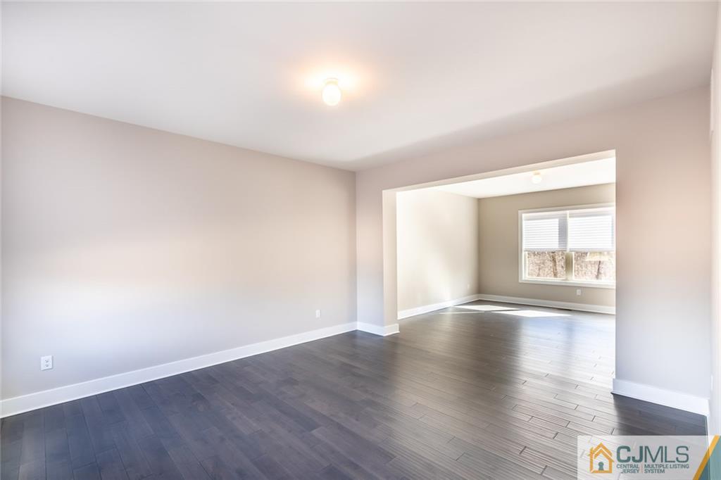 123 Millhurst Road Manalapan, NJ 07726 - Photo 4 of 27 a view of an empty room with wooden floor and a window