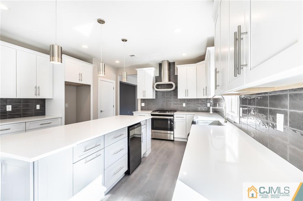 123 Millhurst Road Manalapan, NJ 07726 - Photo 6 of 27 a large kitchen with stainless steel appliances kitchen island granite countertop a refrigerator a sink dishwasher a stove and white cabinets with wooden floor