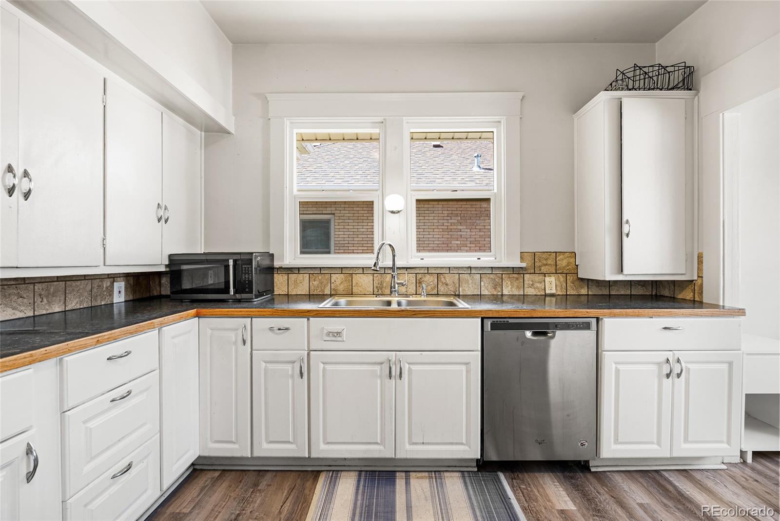1117 16th Street Greeley, CO 80631 - Photo 11 of 37 a kitchen with white cabinets and sink