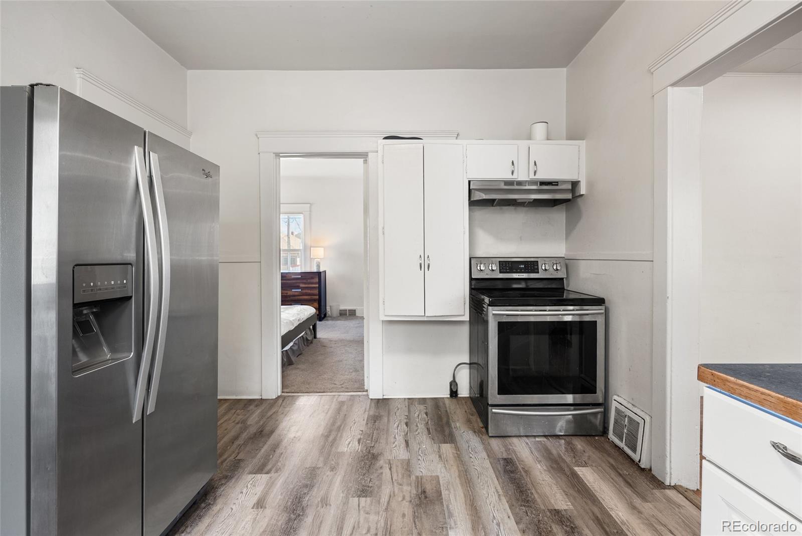 1117 16th Street Greeley, CO 80631 - Photo 12 of 37 a kitchen with stainless steel appliances a refrigerator and a stove top oven