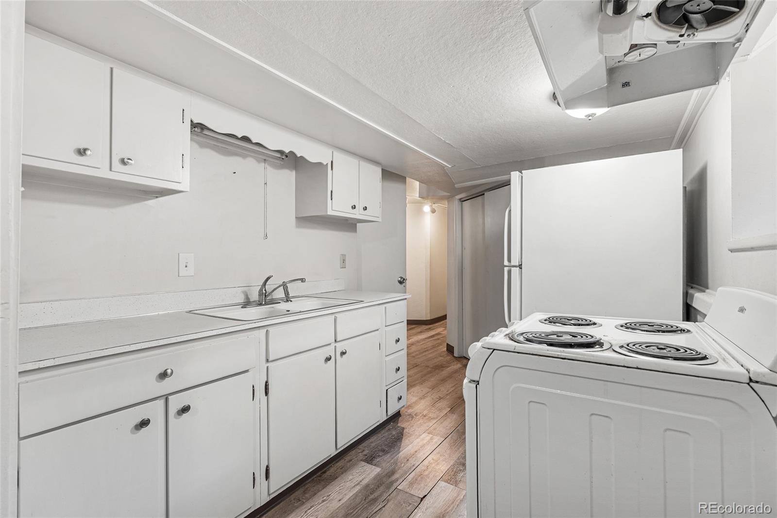 1117 16th Street Greeley, CO 80631 - Photo 23 of 37 a kitchen with sink cabinets and stove