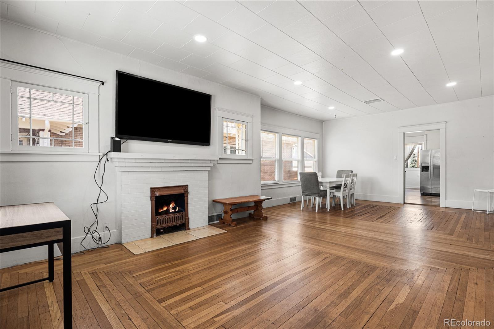 1117 16th Street Greeley, CO 80631 - Photo 4 of 37 a living room with furniture a fireplace and a flat screen tv