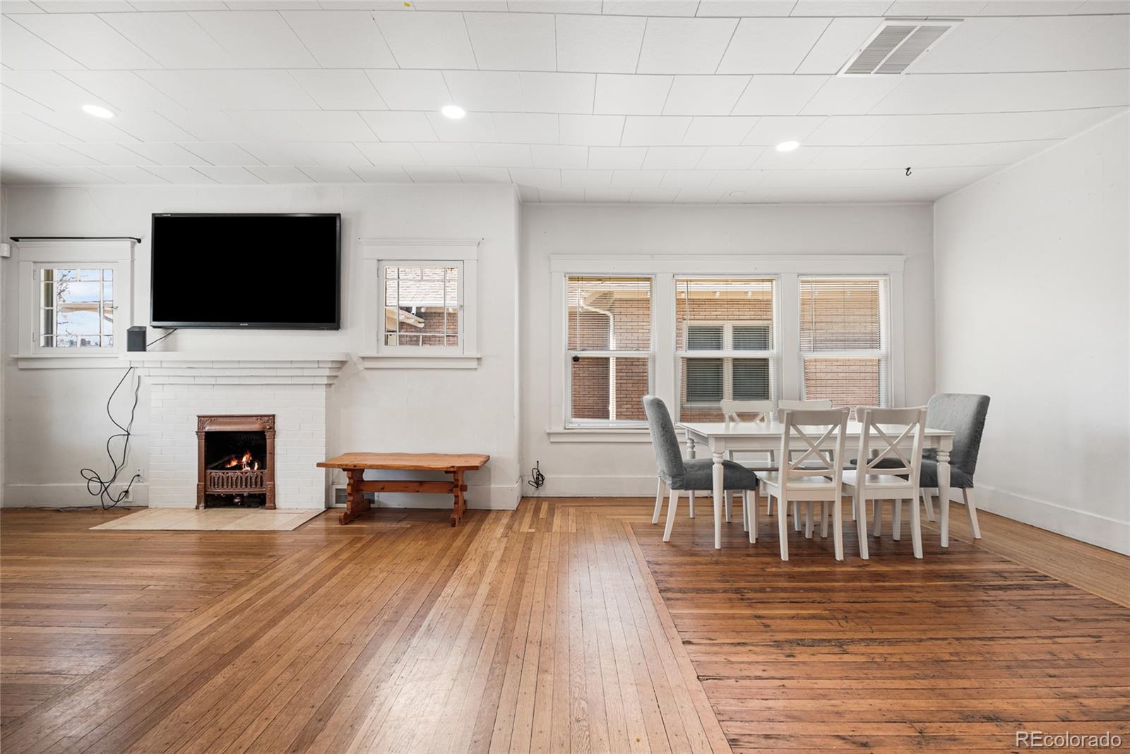 1117 16th Street Greeley, CO 80631 - Photo 8 of 37 a view of a dining room with furniture wooden floor and a fireplace